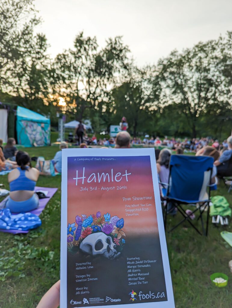 Program of Hamlet by a Company of Fools in front of a crowd and stage