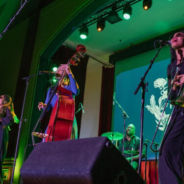 Angelique Francis performing on stage with her band.