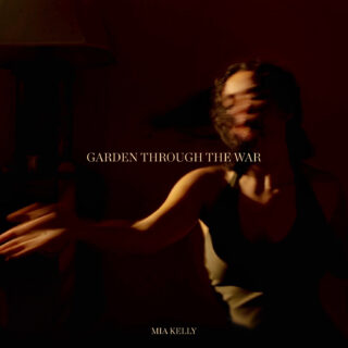 Mia Kelly's album cover: a blurry image of her dancing in the dark, with a warm orange light casted on one side of her.